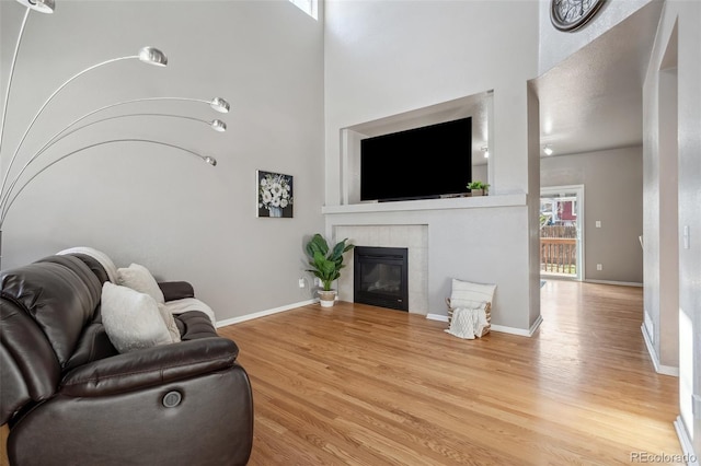 2336 Klein Pl, Colorado Springs, CO 80951 - living area featuring a towering ceiling, baseboards, wood finished floors, and a fireplace