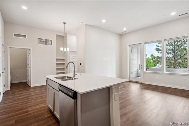 kitchen with sink, an island with sink, dark hardwood / wood-style flooring, decorative light fixtures, and stainless steel dishwasher