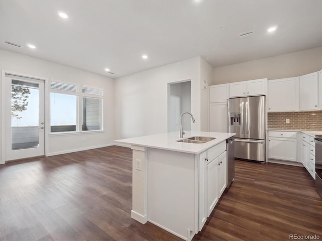 kitchen with dark wood-style flooring, stainless steel appliances, a sink, and light countertops