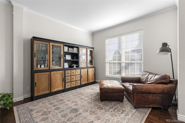 living area featuring baseboards, wood finished floors, and crown molding