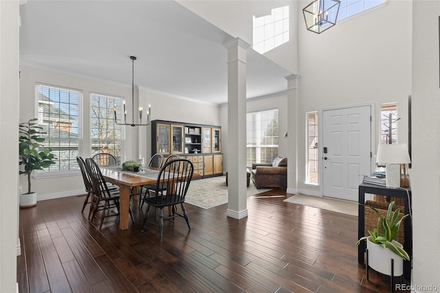 dining room featuring plenty of natural light, dark wood-type flooring, a chandelier, and crown molding