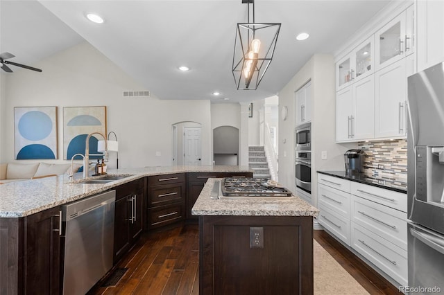 kitchen featuring dark brown cabinetry, a ceiling fan, a kitchen island, and stainless steel appliances