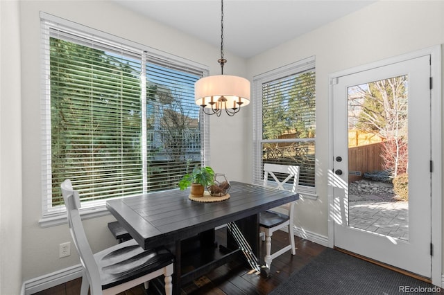 dining space featuring wood finished floors, baseboards, and a chandelier