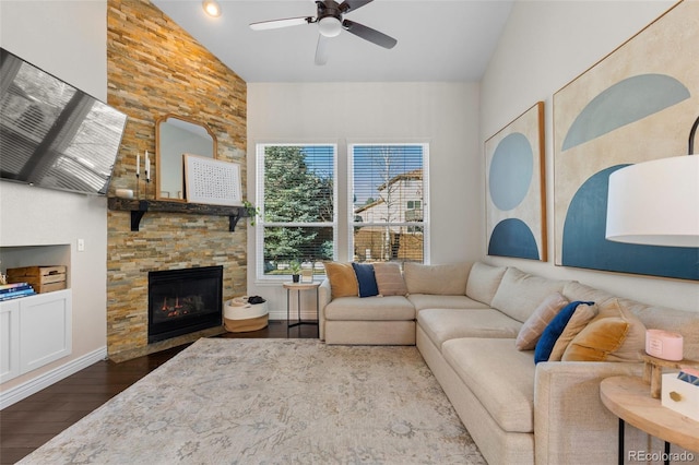 living area with baseboards, dark wood finished floors, a fireplace, high vaulted ceiling, and a ceiling fan