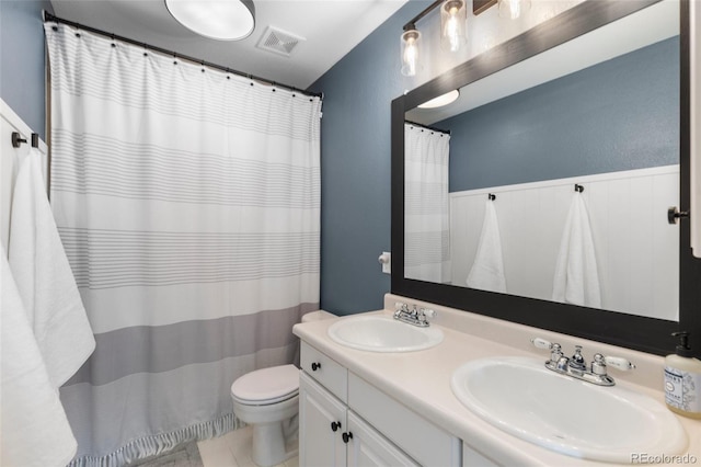 full bath with a sink, visible vents, toilet, and double vanity