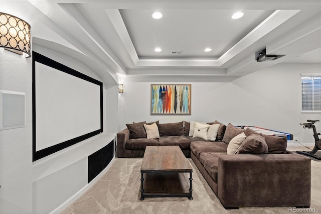 cinema room featuring visible vents, light carpet, a tray ceiling, recessed lighting, and baseboards