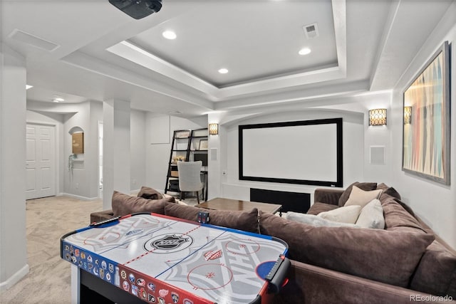 home theater with a tray ceiling, baseboards, and carpet