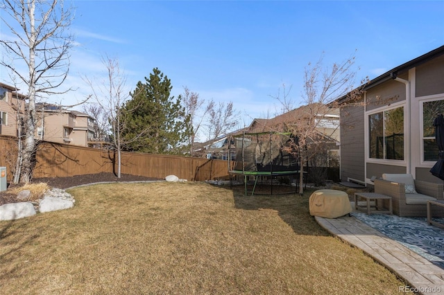 view of yard with a trampoline and fence