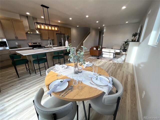 dining room with sink and light wood-type flooring