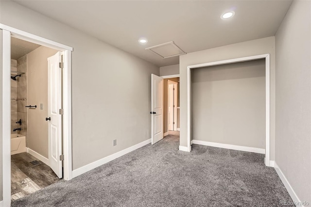 unfurnished bedroom featuring dark carpet and a closet