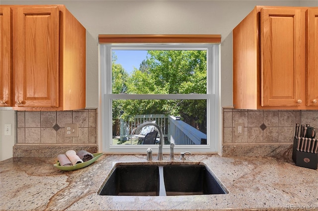 19075 E Grand Cir, Aurora, CO 80015 - kitchen featuring a sink, light stone counters, and decorative backsplash