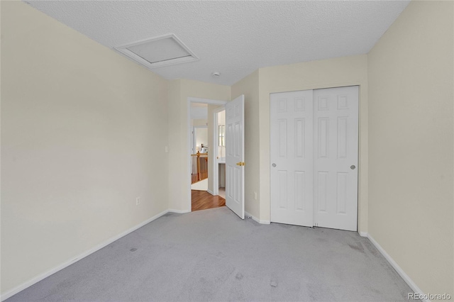 19075 E Grand Cir, Aurora, CO 80015 - unfurnished bedroom with carpet flooring, baseboards, a closet, attic access, and a textured ceiling