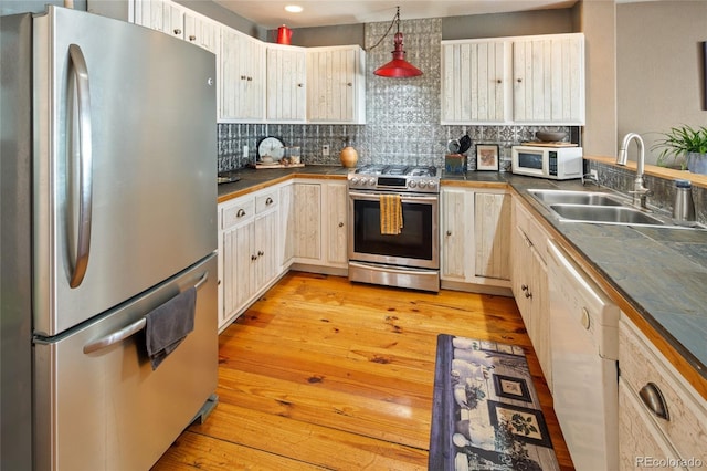 400 W Galena, Moffat, CO 81131 - kitchen with appliances with stainless steel finishes, dark countertops, tasteful backsplash, and light wood-type flooring