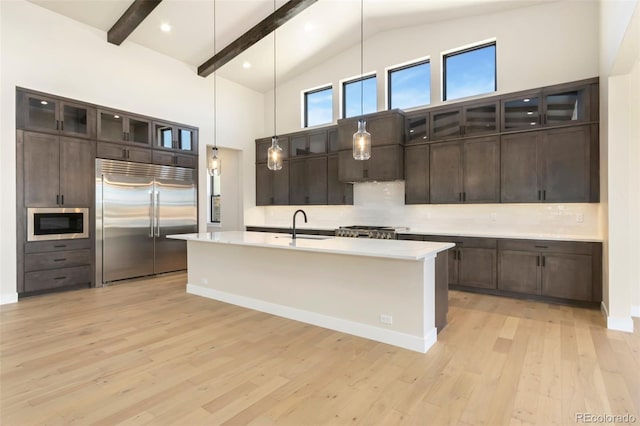 1889 Spring Bloom Dr, Windsor, CO 80550 - kitchen with built in appliances, light countertops, light wood finished floors, tasteful backsplash, and high vaulted ceiling