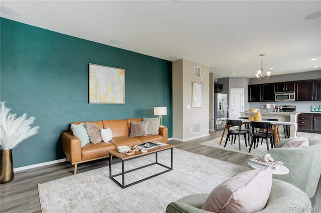 5546 Echo Hollow St, Castle Rock, CO 80104 - living area with a chandelier, light wood-style floors, baseboards, recessed lighting, and an accent wall