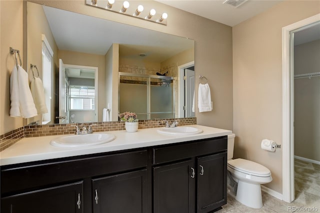 5546 Echo Hollow St, Castle Rock, CO 80104 - full bathroom with a shower stall, double vanity, decorative backsplash, toilet, and tile patterned floors