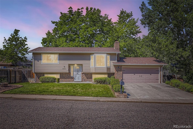 7331 S Webster St, Littleton, CO 80128 - raised ranch featuring a chimney, brick siding, driveway, and an attached garage