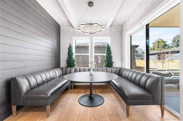 sitting room featuring light wood finished floors and beam ceiling