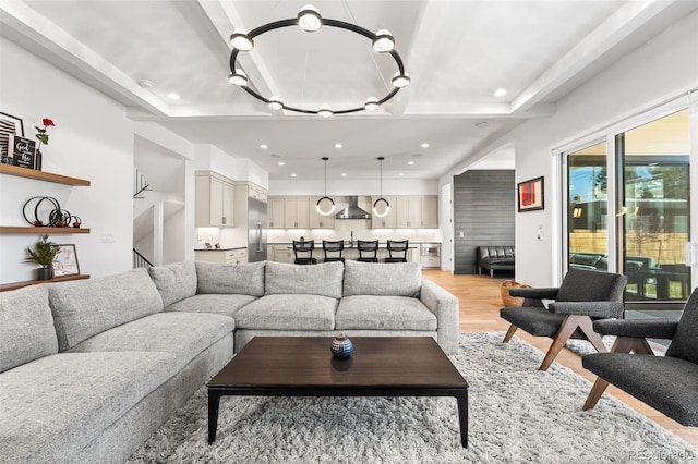 living room featuring stairs, recessed lighting, a notable chandelier, and light wood-style floors