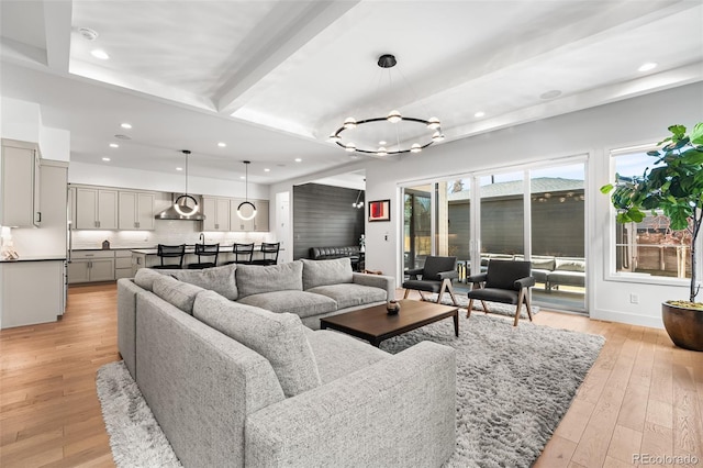 living area with light wood-style floors, recessed lighting, beam ceiling, and baseboards