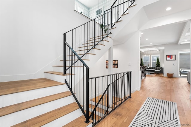 stairway featuring recessed lighting, hardwood / wood-style flooring, and baseboards