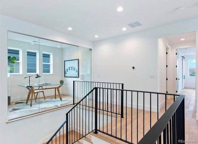 hall featuring recessed lighting, visible vents, baseboards, and an upstairs landing