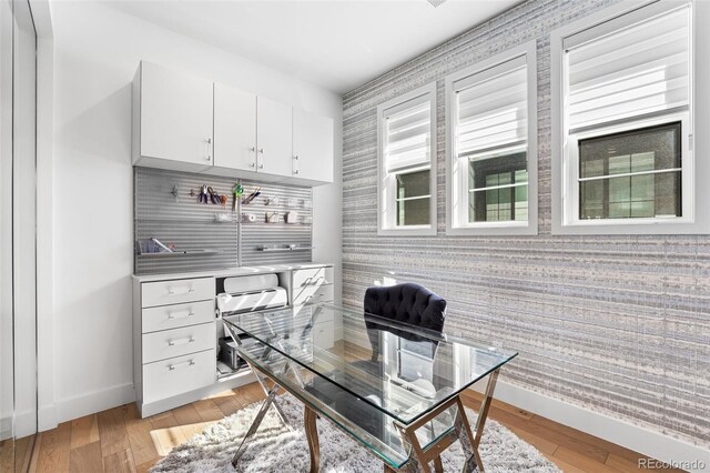 office space featuring light wood-type flooring, wallpapered walls, and baseboards