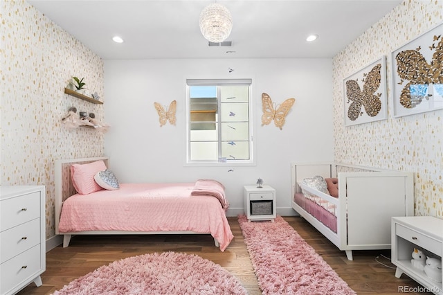 bedroom with wallpapered walls and wood finished floors