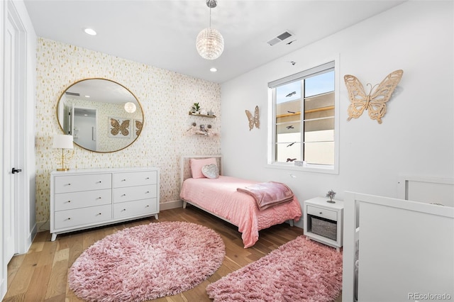 bedroom with wallpapered walls, visible vents, wood finished floors, and recessed lighting