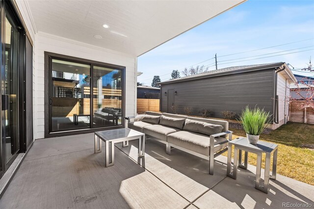 view of patio featuring an outbuilding, fence, and an outdoor living space