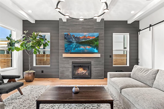 2255 S Monroe St, Denver, CO 80210 - living room featuring wood finished floors, a fireplace, a barn door, wood walls, and beamed ceiling