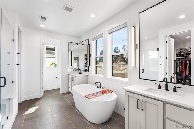 2255 S Monroe St, Denver, CO 80210 - full bathroom with healthy amount of natural light, a shower stall, a freestanding tub, a spacious closet, and recessed lighting