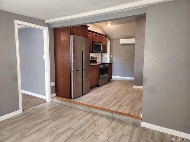 kitchen featuring an AC wall unit, appliances with stainless steel finishes, and lofted ceiling