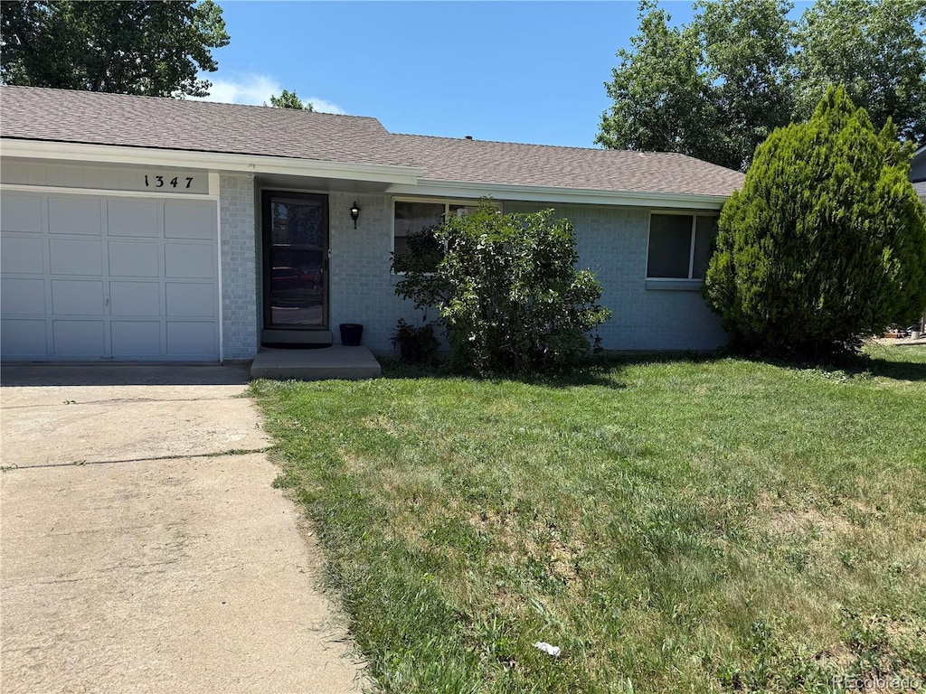 1345 Youngfield St, Golden, CO 80401 - ranch-style home with brick siding, a front yard, an attached garage, concrete driveway, and roof with shingles