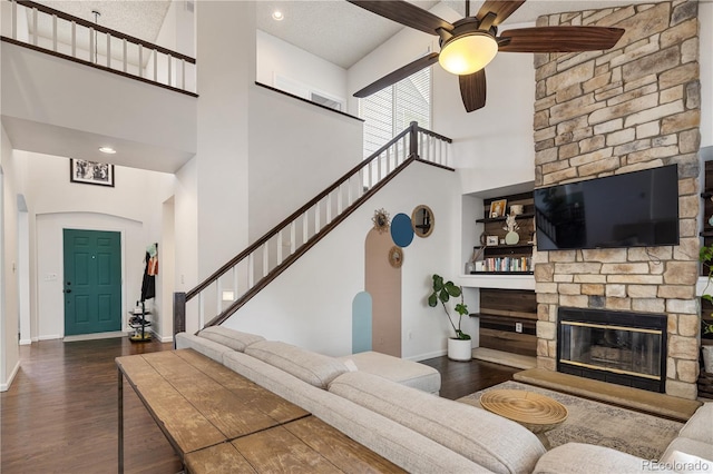 2249 Weatherstone Cir, Highlands Ranch, CO 80126 - living area featuring a high ceiling, a ceiling fan, wood finished floors, a stone fireplace, and stairs