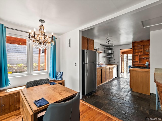 dining space featuring a chandelier and stone tile floors