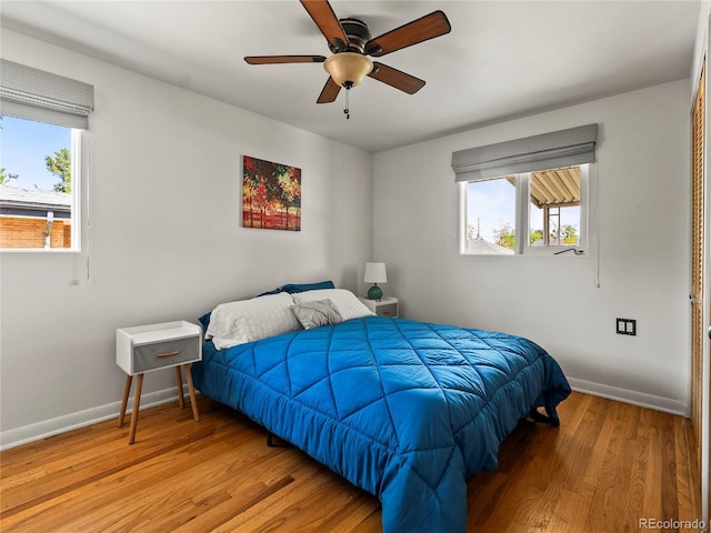bedroom featuring wood finished floors, baseboards, and ceiling fan