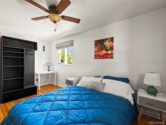 bedroom with wood finished floors, baseboards, and ceiling fan