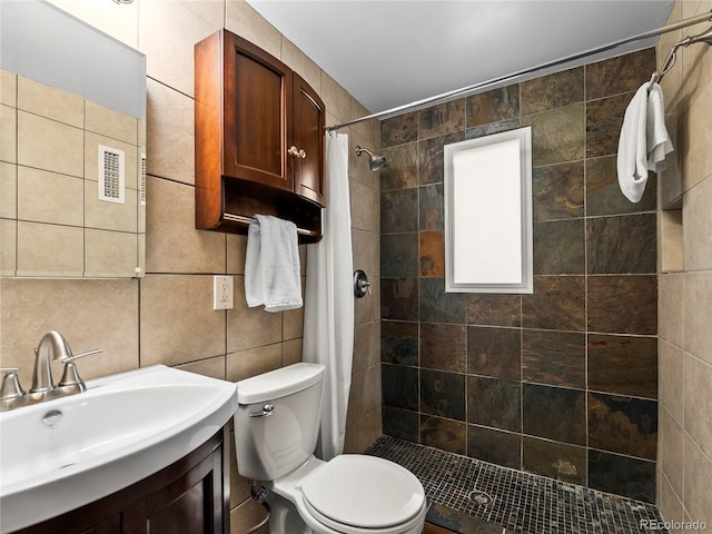 full bathroom with tile walls, a stall shower, toilet, and vanity