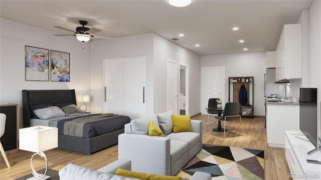 bedroom featuring ceiling fan, sink, and light hardwood / wood-style floors