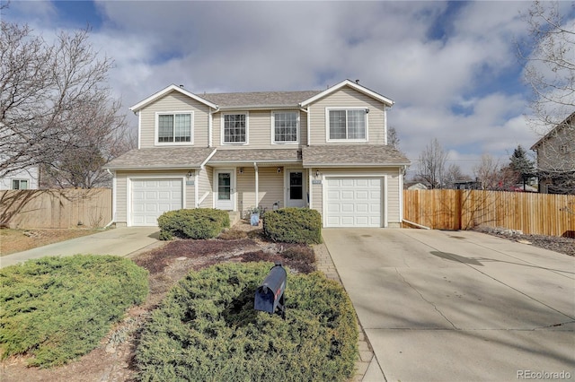 traditional home with concrete driveway, fence, and a garage