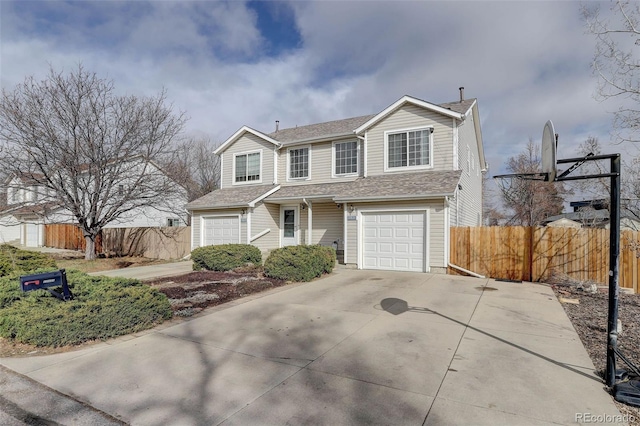 traditional-style house with a garage, driveway, and fence