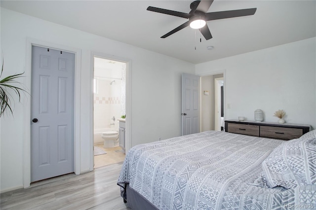 bedroom featuring ceiling fan, ensuite bathroom, and light wood-style floors