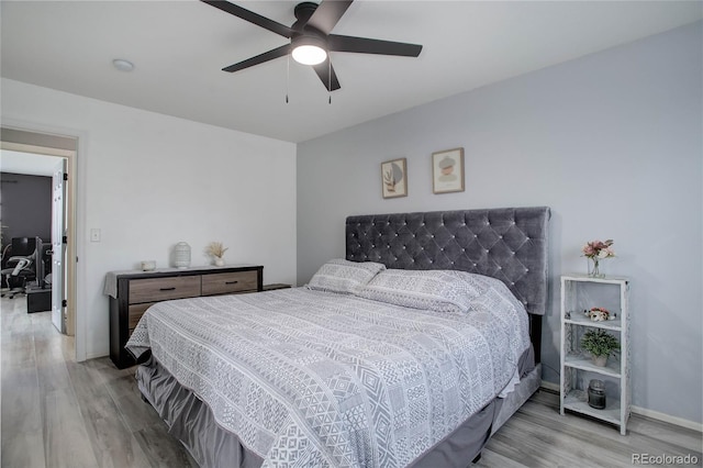 bedroom featuring a ceiling fan, wood finished floors, and baseboards