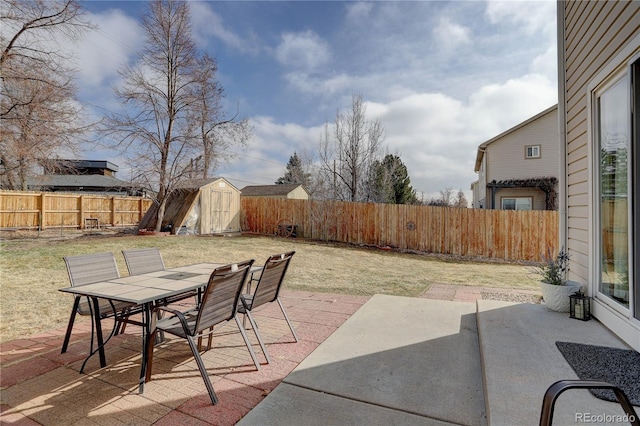 view of patio with a fenced backyard, an outdoor structure, outdoor dining space, and a shed