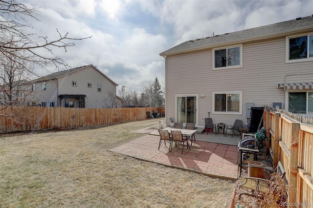 back of house with a yard, a fenced backyard, and a patio area