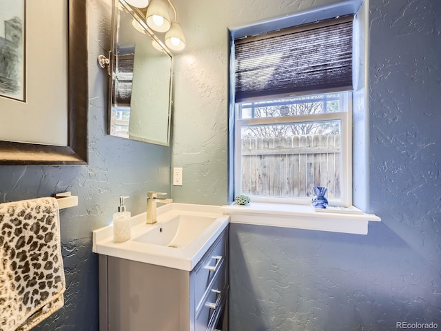 bathroom with vanity and a textured wall