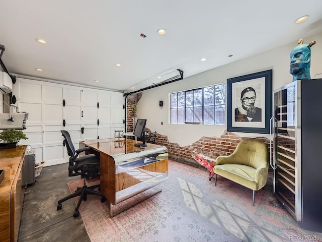 office space featuring beverage cooler, recessed lighting, brick wall, a garage, and concrete flooring