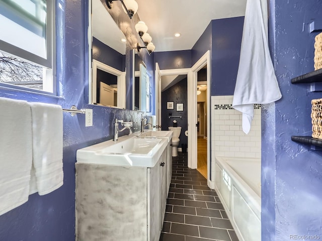 bathroom featuring vanity, a bath, tile patterned floors, toilet, and tile walls