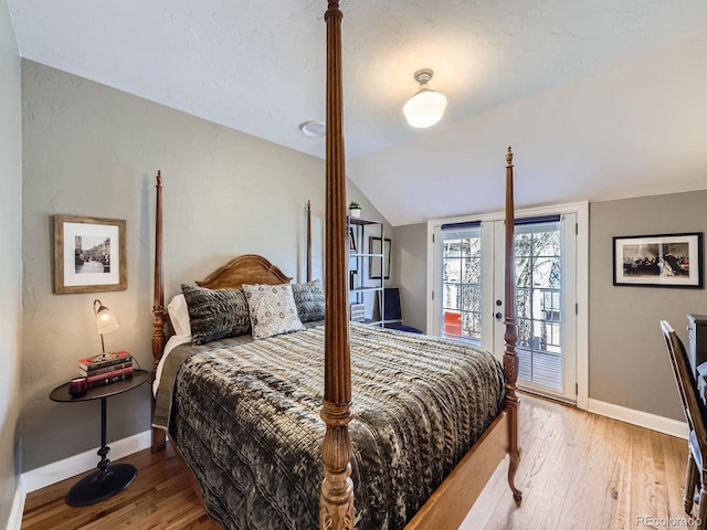 bedroom with lofted ceiling, access to exterior, wood finished floors, and french doors